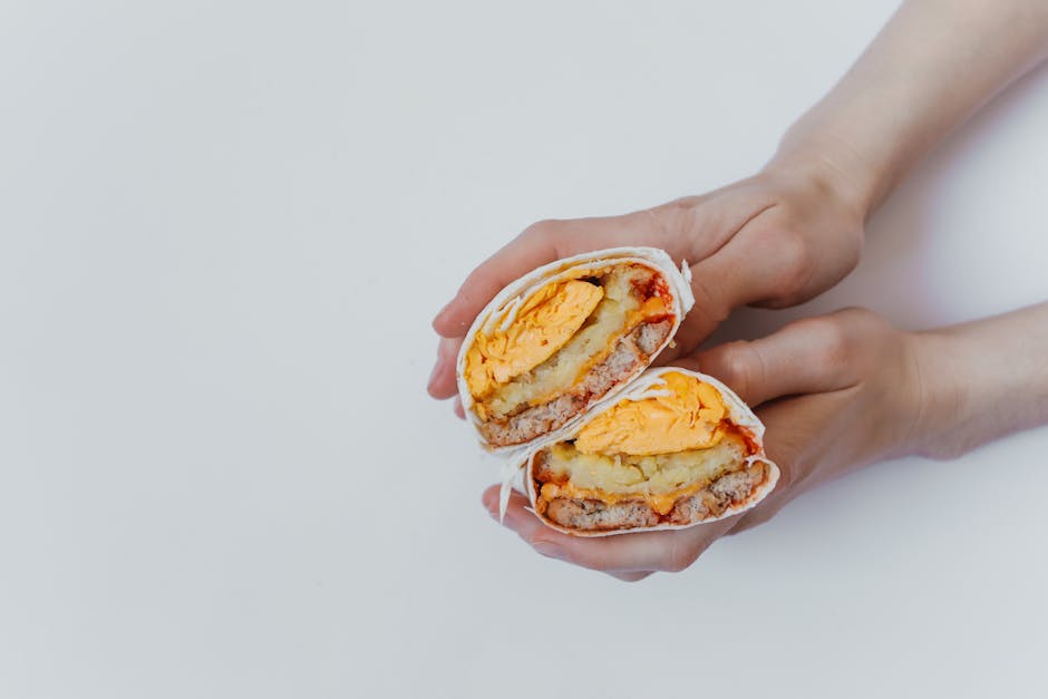 Breakfast burritos wrapped and cut to show fillings.