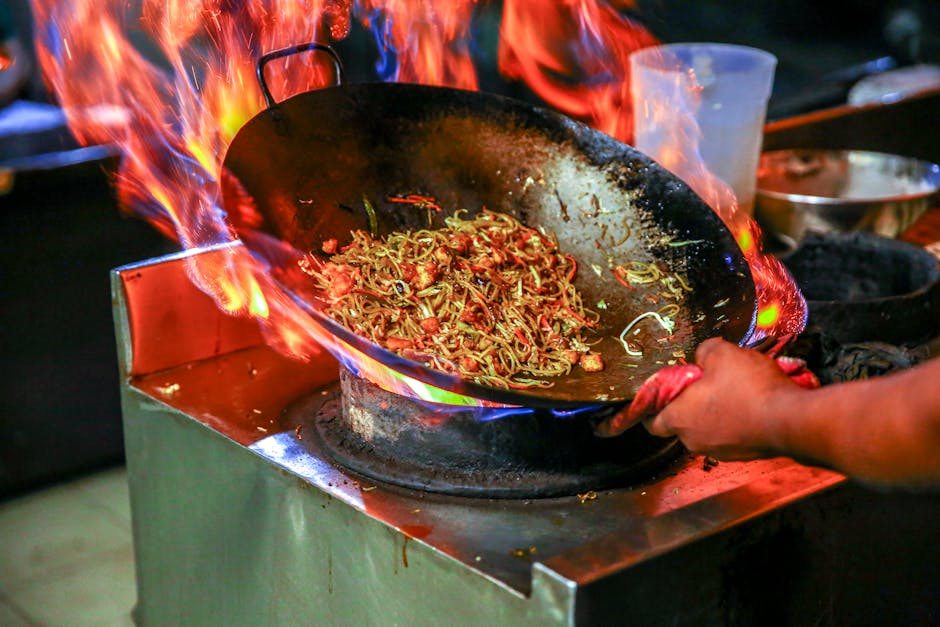 Colorful vegetables and protein being stir-fried in a hot wok.
